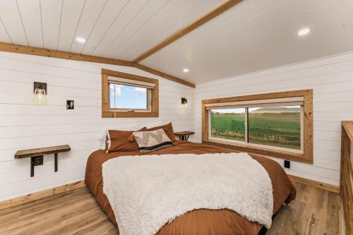 a bedroom with a large bed and a window at Modern Tiny Cabin, with Hot tub in Choteau MT in Choteau