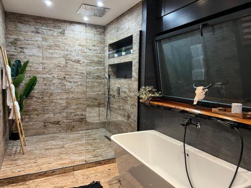 a bathroom with a tub and a glass shower at Villa Lou Santen Guadeloupe in Saint-François