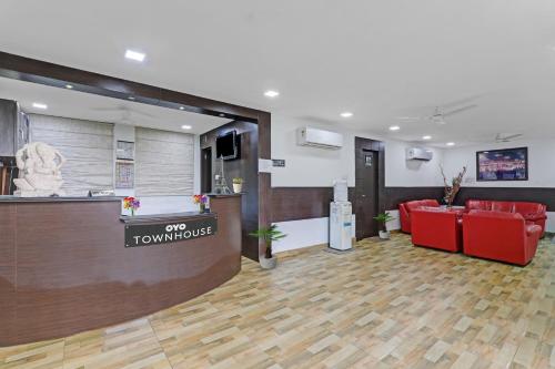 a lobby with red chairs and a reception desk at Townhouse Jalsa Resort in Goshainganj