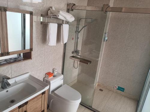 y baño con ducha, aseo y lavamanos. en Meizhou Cloudy B&B en Putian