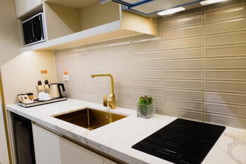 a kitchen with a sink and a counter top at Uma Hotel and Residences in Naga