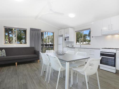 a kitchen and living room with a table and chairs at Blue Dolphin Holiday Resort in Yamba