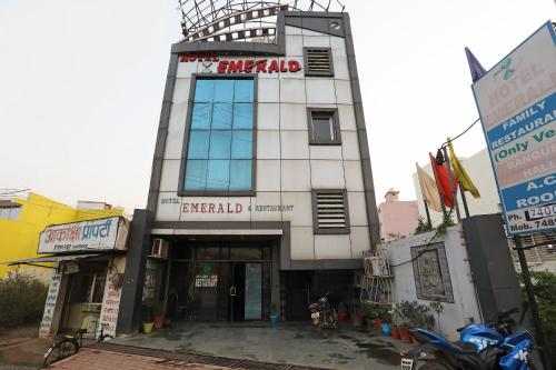 a large white building with a sign on it at OYO Hotel Emerald in Raipur