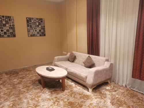 a living room with a couch and a coffee table at فندق دان البلاتيني in Al Madinah