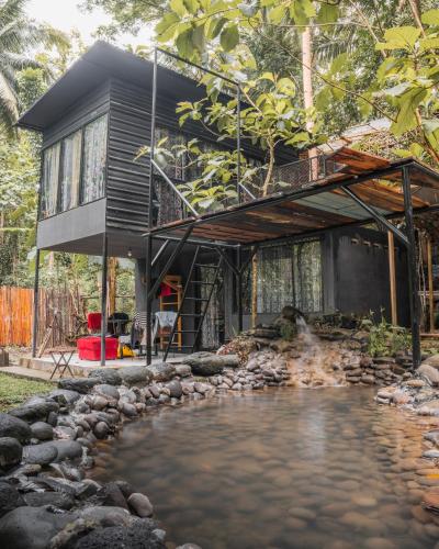 ein Haus mit einem Teich davor in der Unterkunft Awandaru Village in Yogyakarta