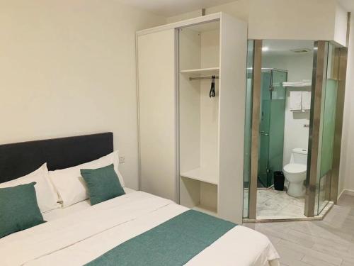 a bedroom with a bed and a bathroom with a toilet at YueShe Apartment - HongQiao Longbai Xincun in Shanghai