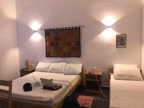 - une chambre avec 2 lits et un ordinateur portable sur le lit dans l'établissement Orchidia House Santa Fe Bantayan Island, à Île Bantayan