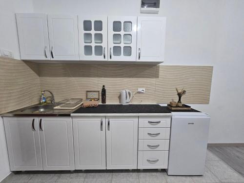 a kitchen with white cabinets and a sink at SLEEP & GO in Surčin