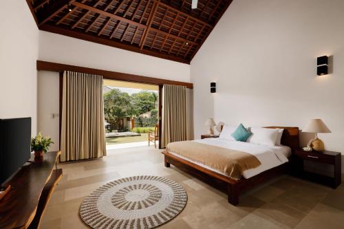 a bedroom with a bed and a large window at OMEGIA Canggu by Nakula in Canggu
