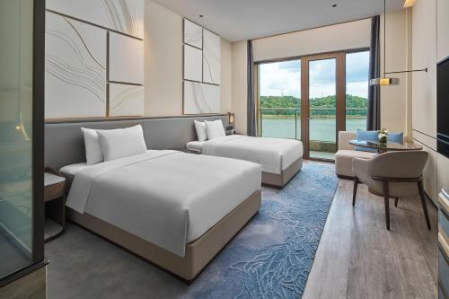 una camera d'albergo con due letti e una televisione di Crowne Plaza Ganzhou, an IHG Hotel a Ganzhou