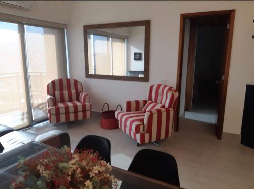 sala de estar con 2 sillas y espejo en TOP LEBLON Flats, en Río de Janeiro