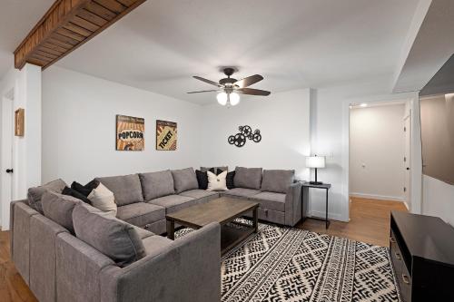 a living room with a couch and a ceiling fan at The Lofts on Indian Point - Near Silver Dollar City in Branson