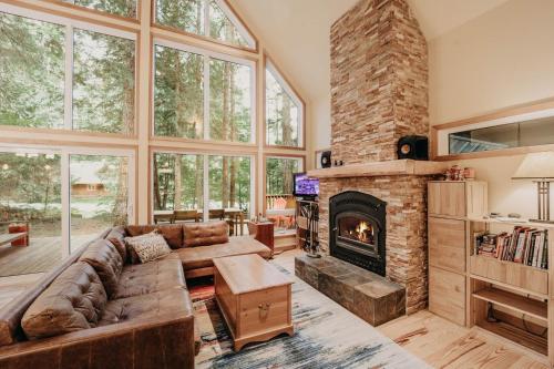 een woonkamer met een bank en een open haard bij 40GS – WiFi - WithD – Hot Tub - Sleeps 8 cabin in Glacier
