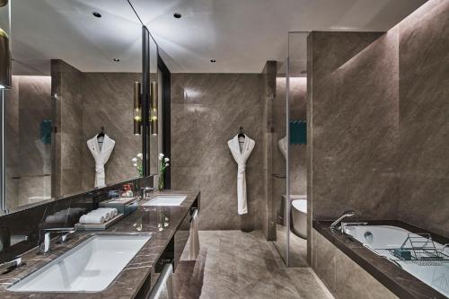 贛州的住宿－赣州皇冠假日酒店，浴室配有两个盥洗盆和浴缸。