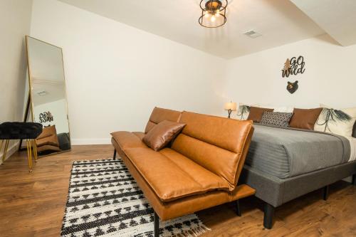a bed with a leather couch in a room at The Lofts on Indian Point - Near Silver Dollar City in Branson
