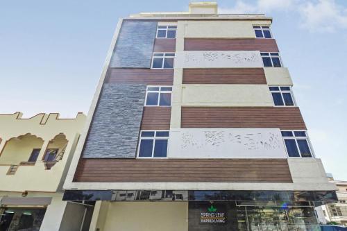 a tall building with brown and white at Capital O Hotel Green Leaf in Gachibowli