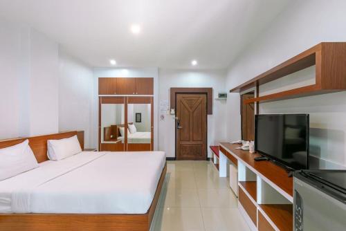 a bedroom with a bed and a flat screen tv at River Hotel Pattani in Pattani