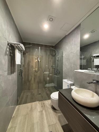 a bathroom with a shower and a toilet and a sink at Sydney RiseOn Hotel in Sydney