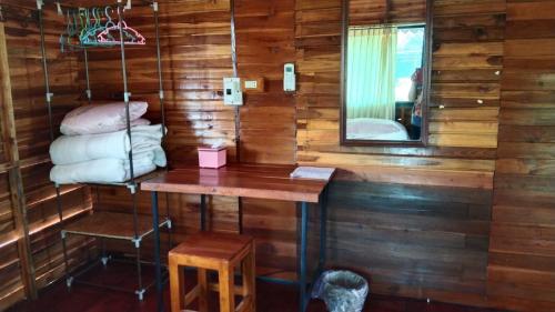a room with wooden walls and a table and a mirror at Prabpluem Resort in Chiang Klang