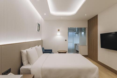 pokój hotelowy z łóżkiem i telewizorem w obiekcie Arban Hotel w Pusanie