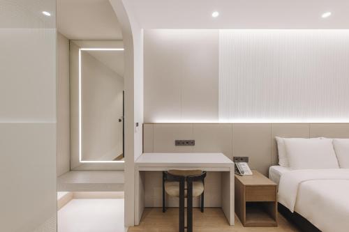 - une chambre avec un lit et un bureau à côté d'un lit dans l'établissement Arban Hotel, à Busan