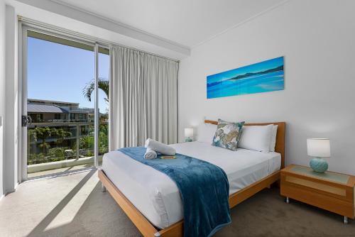 ein Schlafzimmer mit einem Bett und einem großen Fenster in der Unterkunft Peninsula Airlie Beach in Airlie Beach