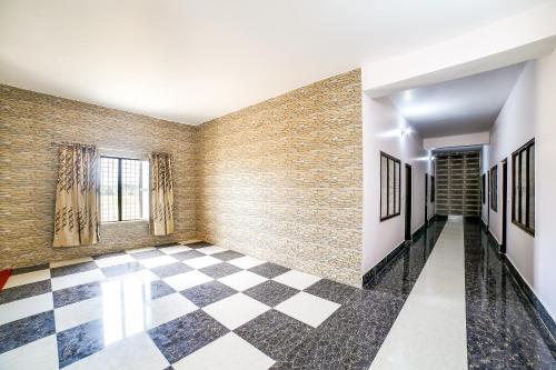 a hallway with a checkered floor and a brick wall at Super OYO Hotel Kalindi in Chūharpur