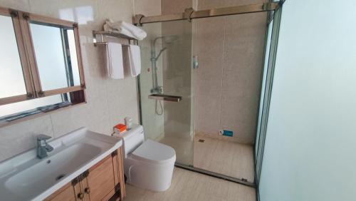 a bathroom with a shower and a toilet and a sink at Meizhou Cloudy B&B in Putian
