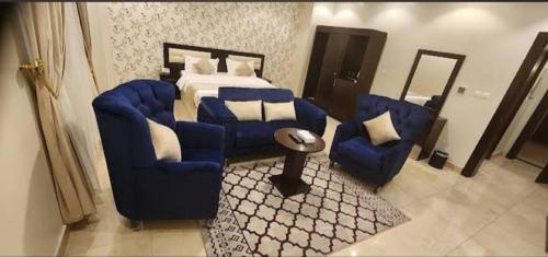 a bedroom with a bed and two chairs and a table at الجوهرة البيضاء للشقق المخدومة in Jeddah