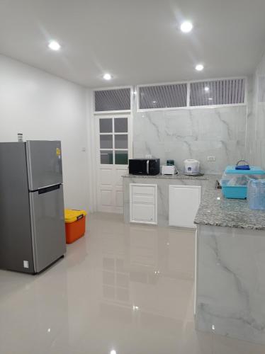 a kitchen with a stainless steel refrigerator in a room at Sealife4 Beach Pool Villa in Rayong