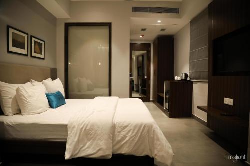 a bedroom with a large bed and a television at Belvedere Suites in Greater Noida