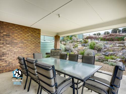 a dining room with a glass table and chairs at Sweeping Ocean Views 4BR on One Acre in Encounter Bay