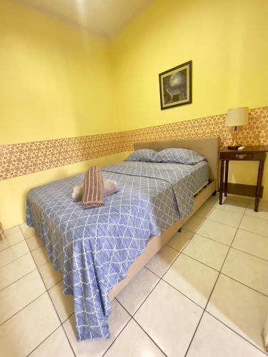 a bedroom with a bed with a blue comforter at Emerald Apartments INC in Georgetown