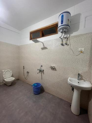 a bathroom with a toilet and a bidet and a sink at Mondruk Homestay in Dirang Dzong