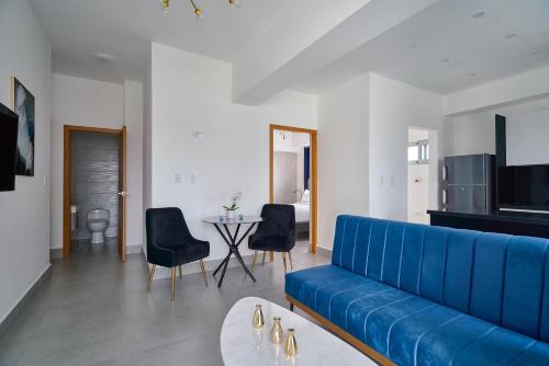 a living room with a blue couch and a table at Central Suites Tower in Santo Domingo