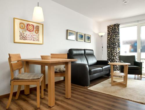 ein Wohnzimmer mit einem Tisch und einem Sofa in der Unterkunft Residenz am Yachthafen Hornhecht in Kirchdorf