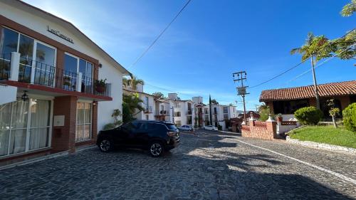 a black car parked in a street next to buildings at Villas de la Montaña in Taxco de Alarcón