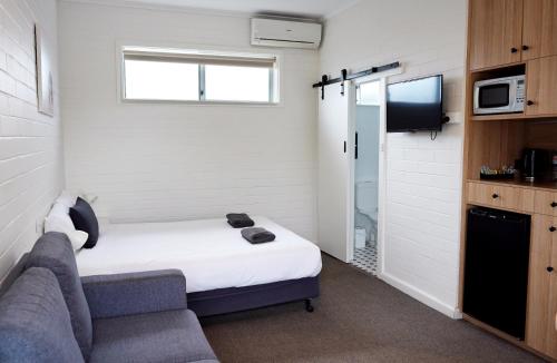 a small room with a bed and a couch at Guichen Bay Motel in Robe