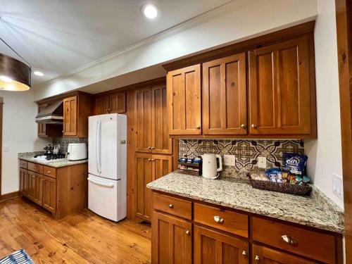 a kitchen with wooden cabinets and a white refrigerator at Golden Acres Ranch Hot Tub+Gameroom+Creek & wifi in Highlands