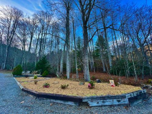 a garden with flowers in the middle of a forest at Golden Acres Ranch Hot Tub+Gameroom+Creek & wifi in Highlands