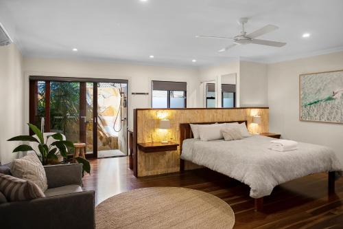 - une chambre avec un grand lit et un canapé dans l'établissement Away Guesthouse- Away on Shirley Lane, à Byron Bay