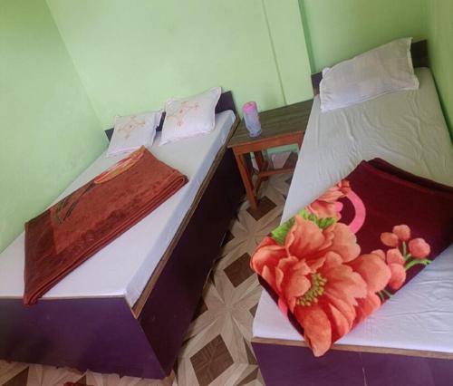 due letti uno accanto all'altro in una stanza di Gujrati Marwadi Cottage by StayApart a Barkot
