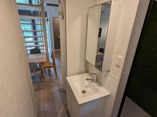 a bathroom with a sink and a mirror and a table at Summit Chalets in Hakuba