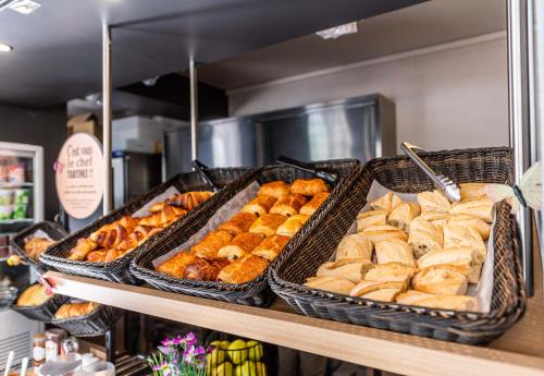three baskets of bread and pastries on a shelf at B&B HOTEL Saint Jean De Maurienne in Sainte-Marie-de-Cuines