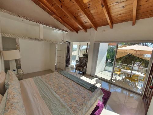 a bedroom with a bed and a balcony with a table at Casa Tamarindo in Alpuyeca