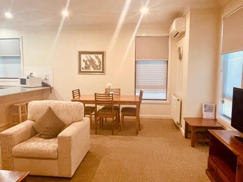 a living room with a table and a chair at Mary MacKillop Spirituality Centre, Melbourne in Melbourne