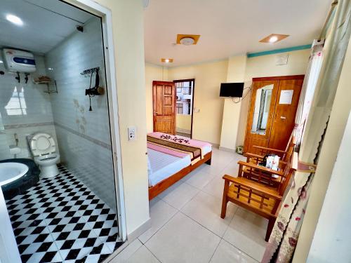 a bathroom with a bed and a shower and a toilet at Manh Vuong Hotel CatBa in Cat Ba