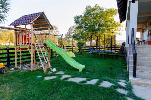 a playground with a slide and a swing set at Casa Iager - Vama Buzaului 