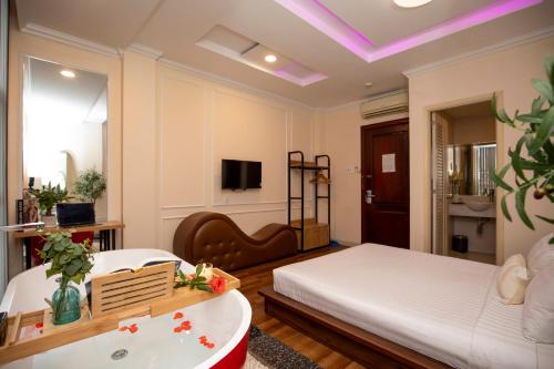 een slaapkamer met een bed, een bad en een tv bij An Thinh Hotel - Ben Thanh Central Market in Ho Chi Minh-stad