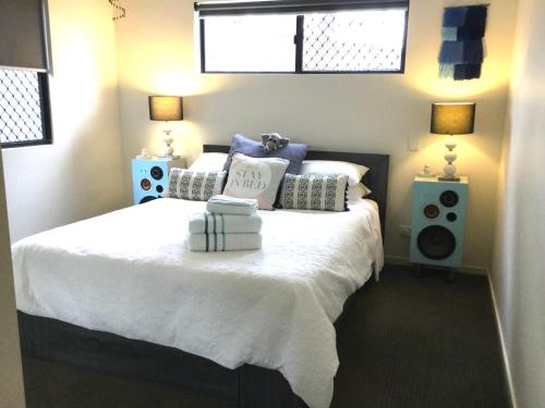 um quarto com uma cama grande e almofadas azuis e brancas em Bowen Sunrise Retreat Homestay em Bowen